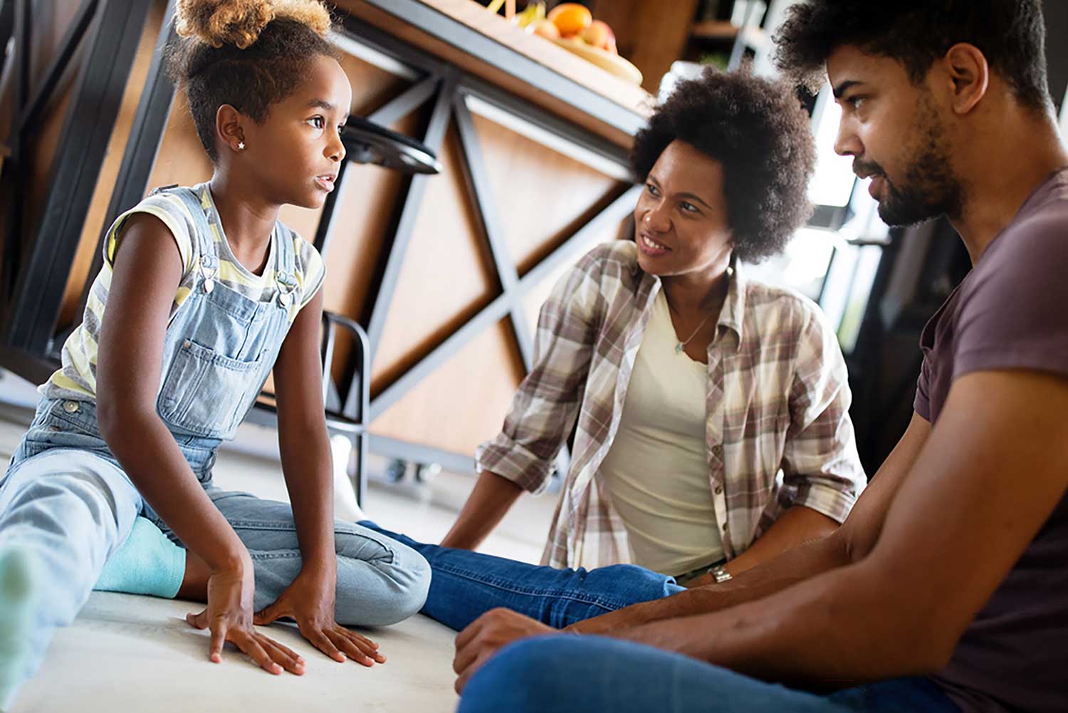 Parents and child sitting on the floor having a conversation